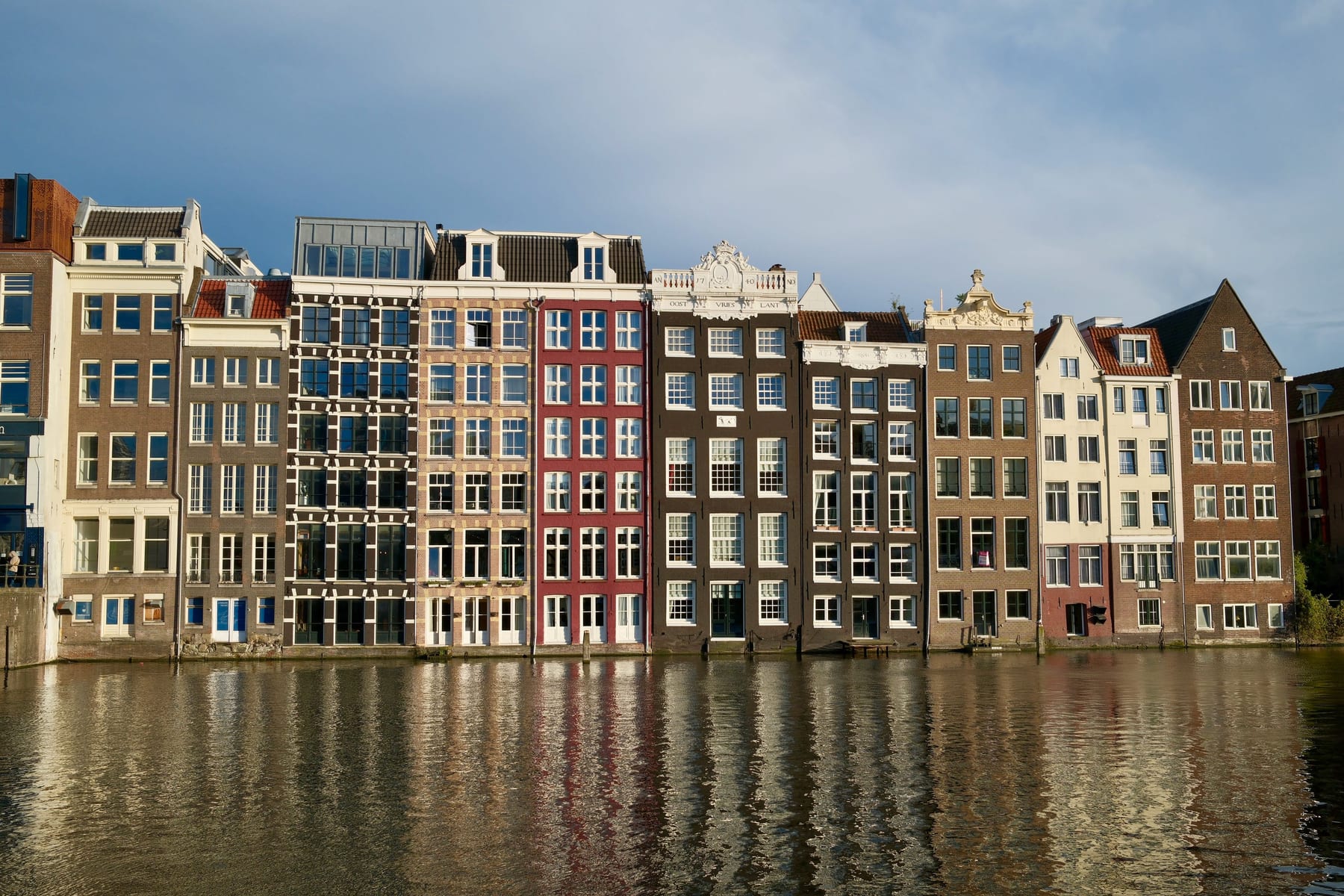 Rij Amsterdamse grachtenpanden in ochtendlicht